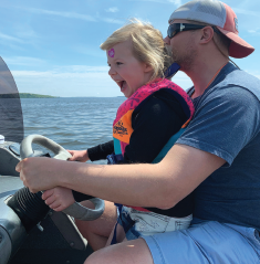 Dad and daughter driving a boat